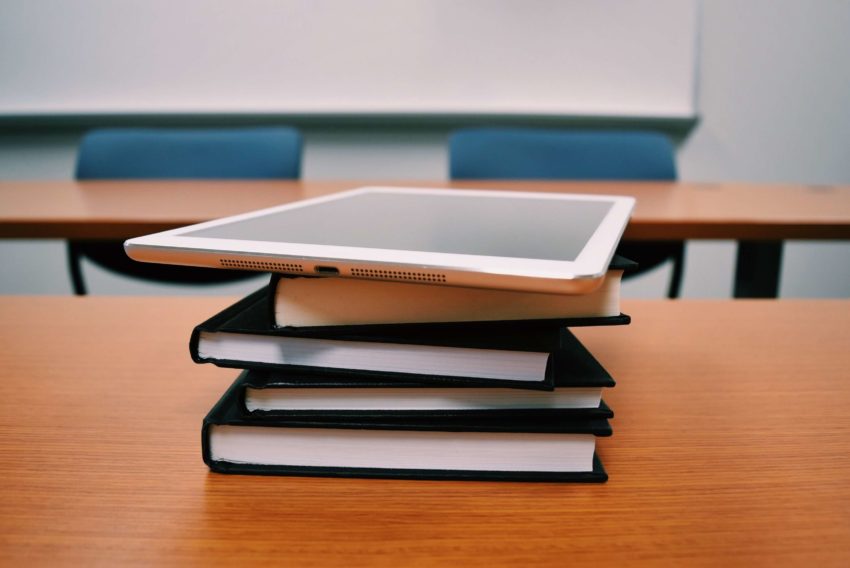 iPad balanced on stack of books introducing technology into education