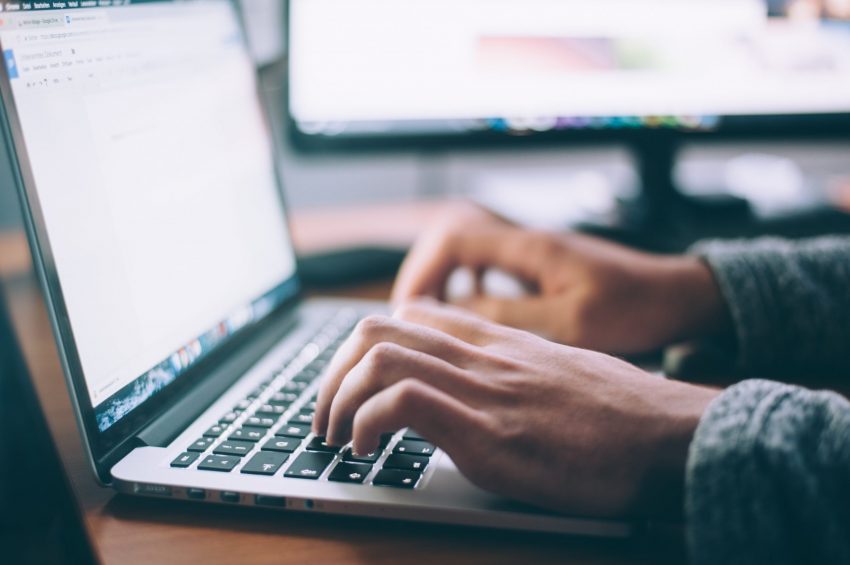 UoPeopel student typing an academic and formal paper on a laptop