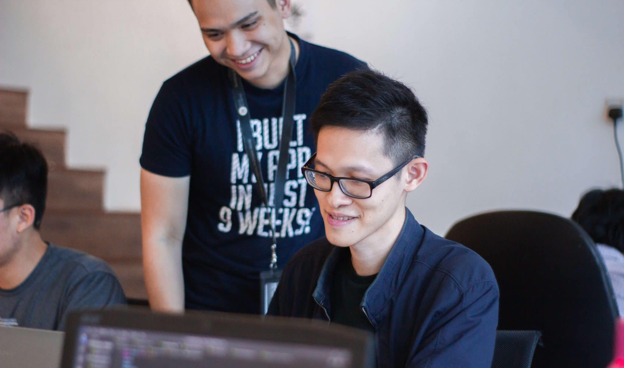 Mentor helping a mentee at their computer