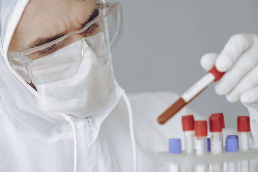 University of the People student with PPE equipment and test tubes