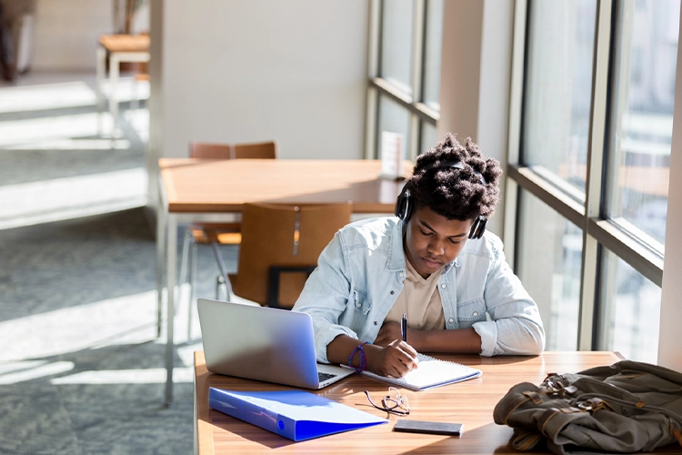 a male college student working at his desk