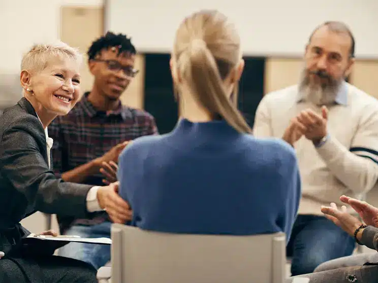 a female industrial organizational psychologist being applauded by her peers