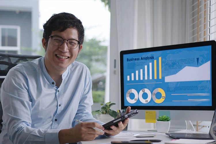 MBA Finance male student seated next to his desktop