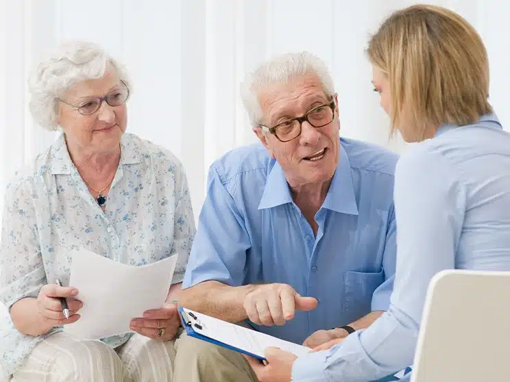 a female healthcare advocate advising an elderly couple